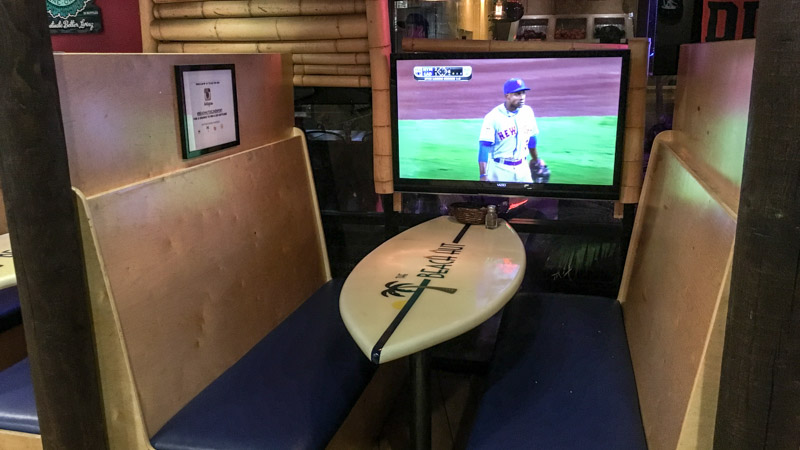 Surf board tables and your own television to watch your favorite game while you eat